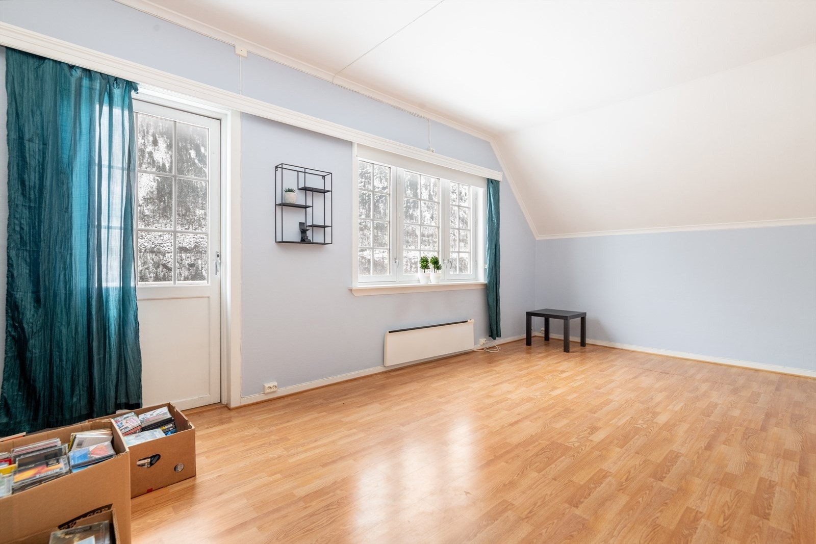 Her er det en lys loftstue - praktisk plassert ved barnerommene. Fra loftstuen er det utgang til en altan beliggende høyt og fritt. Fra altanen er det utsikt ut over nærområdet. Galleribilde