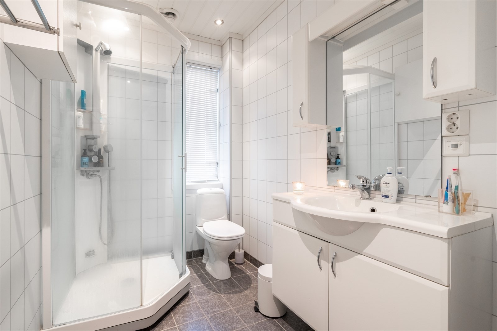 Pent bad fra 2009 med flis på gulv og baderomsplater på vegger. Her er det dusjkabinett, toalett og innredning med heldekkende hvit vask, under- og overskap med slette fronter og speil. Det er varmekabler i gulv og elektrisk styrt vifte (2023). Galleribilde