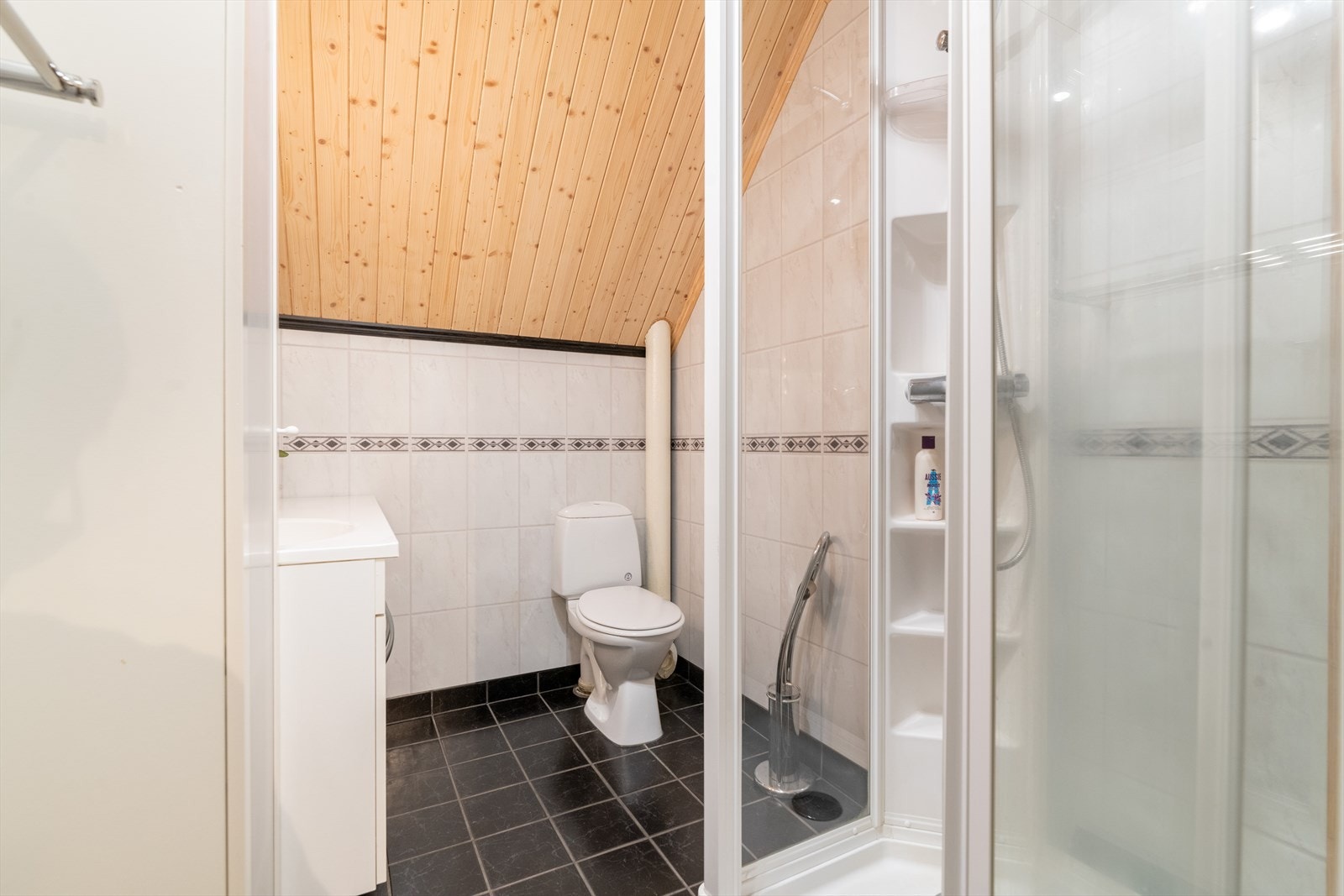 Badet i denne etasjen er også fra 2009, og har flis på gulv og baderomsplater på vegger. Her er det toalett, dusjkabinett og innredning.
Det er varmekabler i gulv og elektrisk styrt vifte. Galleribilde