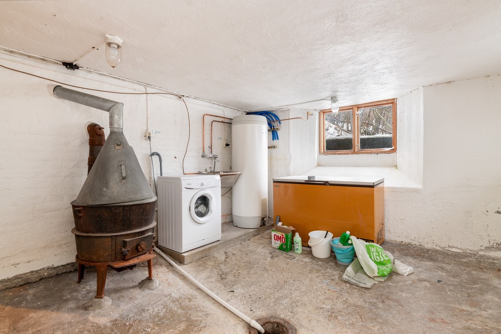 I kjelleren er det et eldre vaskerom med plass til vaskemaskin og skyllekum montert på vegg. 300l varmtvannstank er også plassert her. Galleribilde