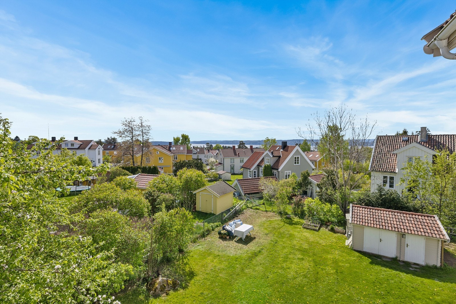 Boligen disponerer egen hagedel. Utsikt fra verandaen til hagen Galleribilde