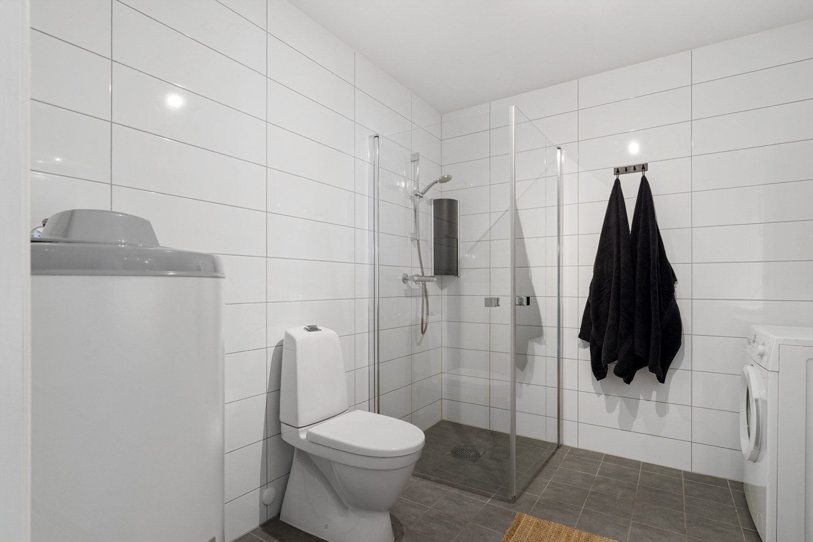 Badet har tidsmessig innredning med gode oppbevaringsmuligheter, og i rommet er det også opplegg for vaskemaskin. Galleribilde