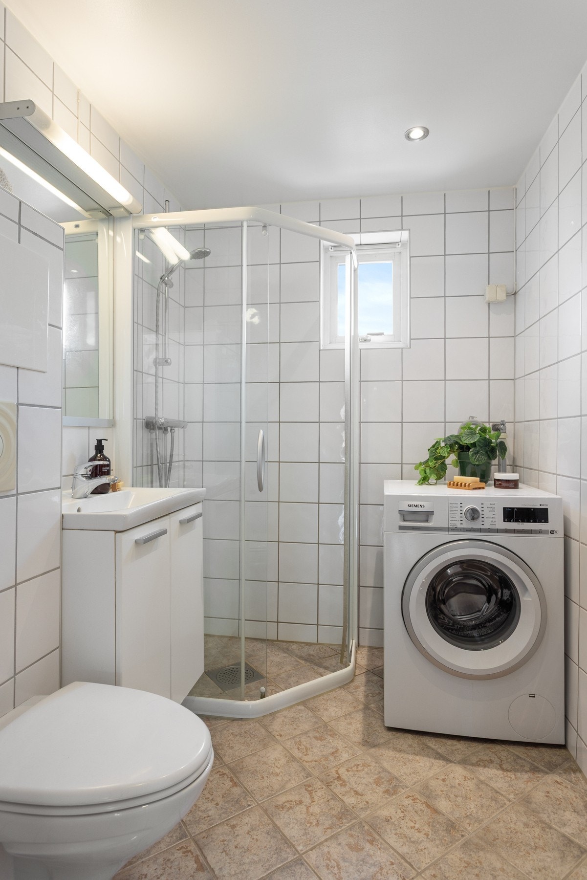 Badet er utstyrt med baderomsinnredning med to skap, samt servant med speil og lys over. Videre er det dusjhjørne og vegghengt toalett. Galleribilde