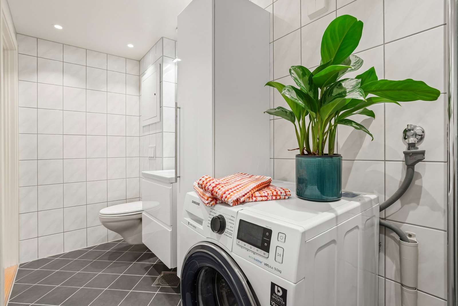 Badet har varmekabler i gulv, downlights i tak og opplegg for vaskemaskin Galleribilde