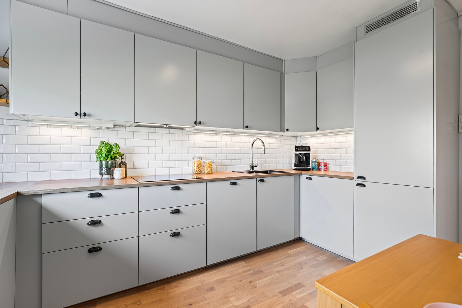 Kjøkkenet har integrert induksjonsplatetopp, stekeovn, oppvaskmaskin og kjøl/fryseskap Galleribilde