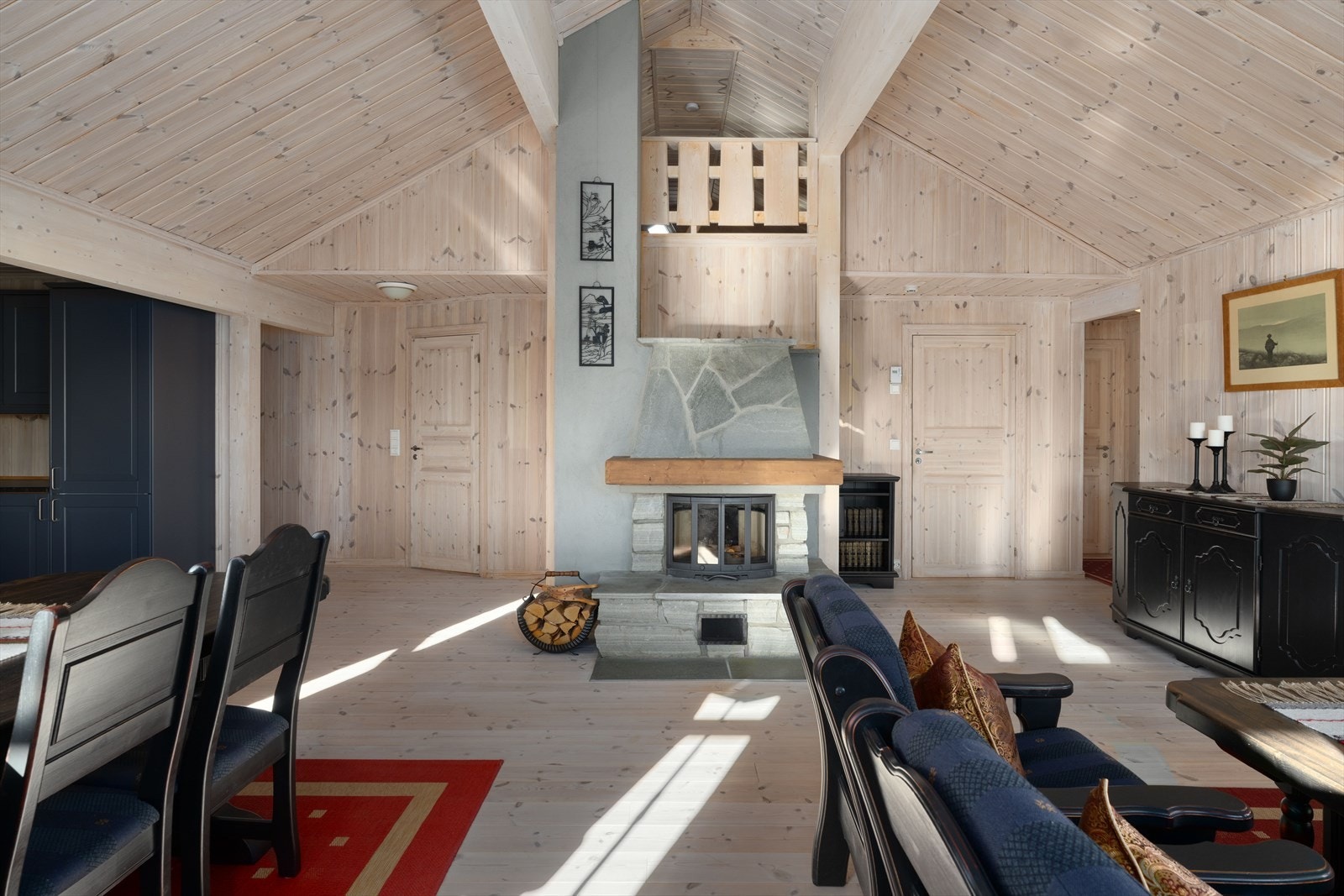 Åpen og sosial løsning mellom kjøkken, spisestue og stue. En flott peis med innsats gir kos og god varme i den kalde årstida. Galleribilde