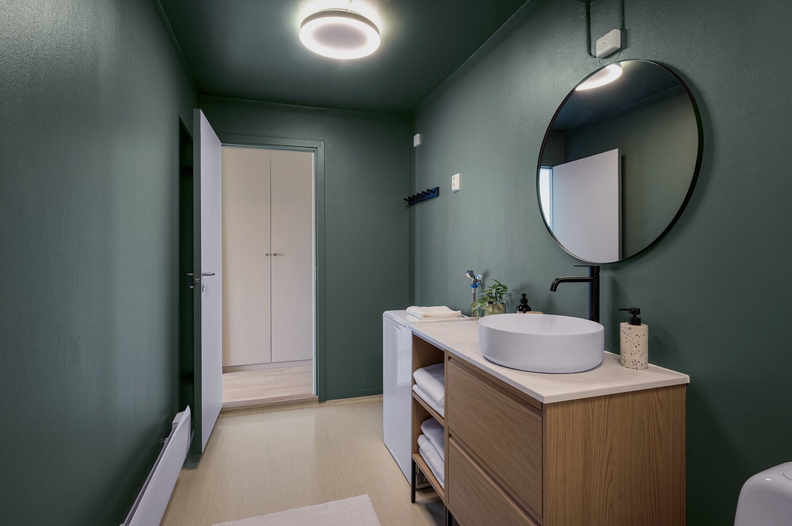 Innredningen består av toalett, servant nedfelt i innredning og dusjhjørne med svingbare glassdører. Opplegg for vaskemaskin. Mekanisk avtrekk. Galleribilde