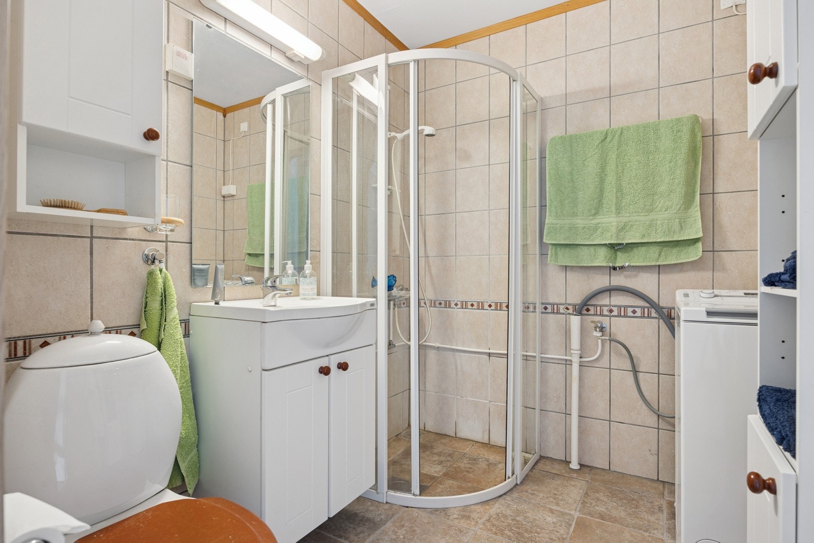Romslig, flislagt badeværelse fra 2003 på 4 kvm. Badet har opplegg for vaskemaskin og gir gode muligheter for oppbevaring i hyller og skap. Galleribilde