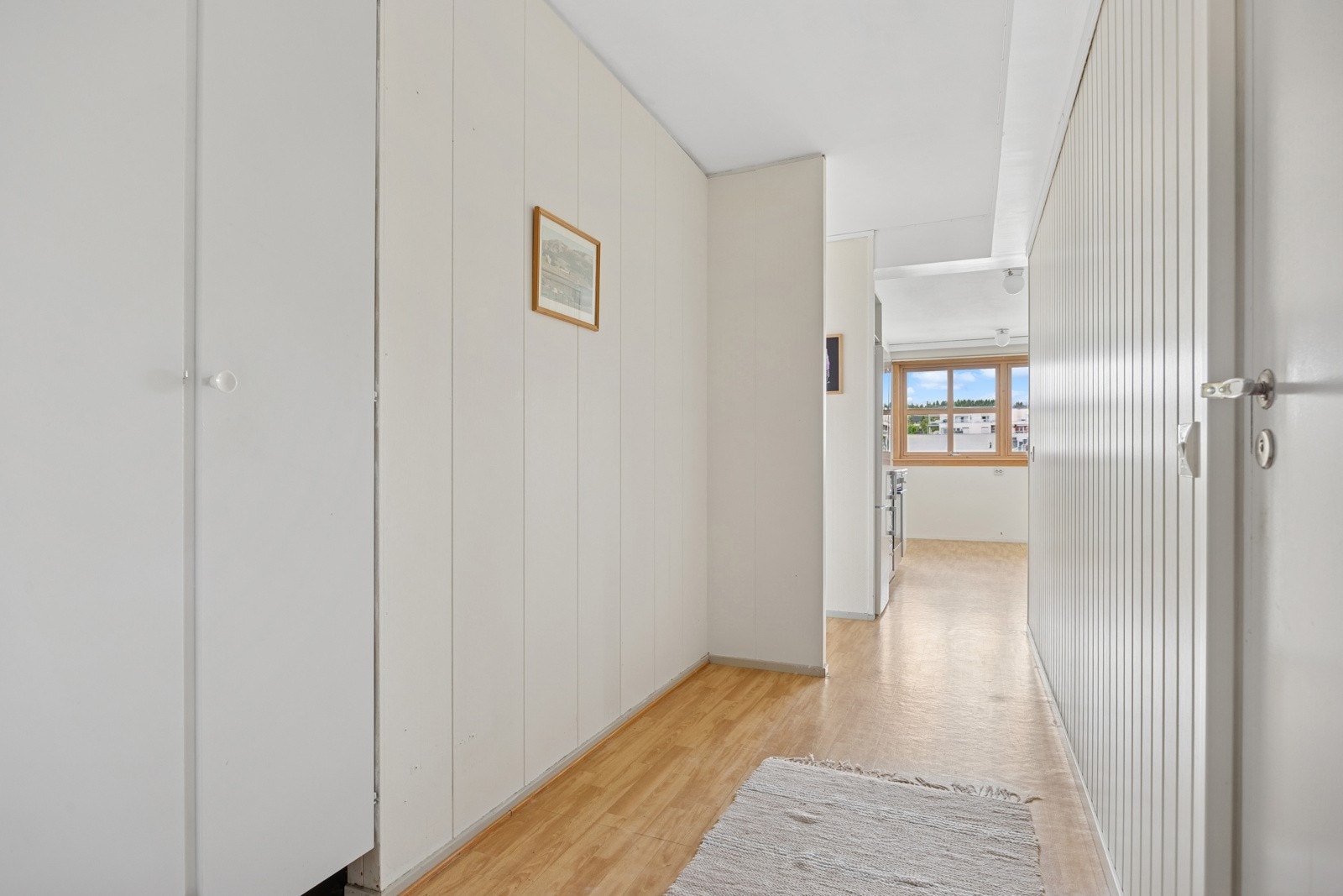 Velkommen inn! Etter å ha tatt trappen opp til fjerde etasje kommer man inn til en lys entré med innfelt garderobeskap for klesavheng. Galleribilde