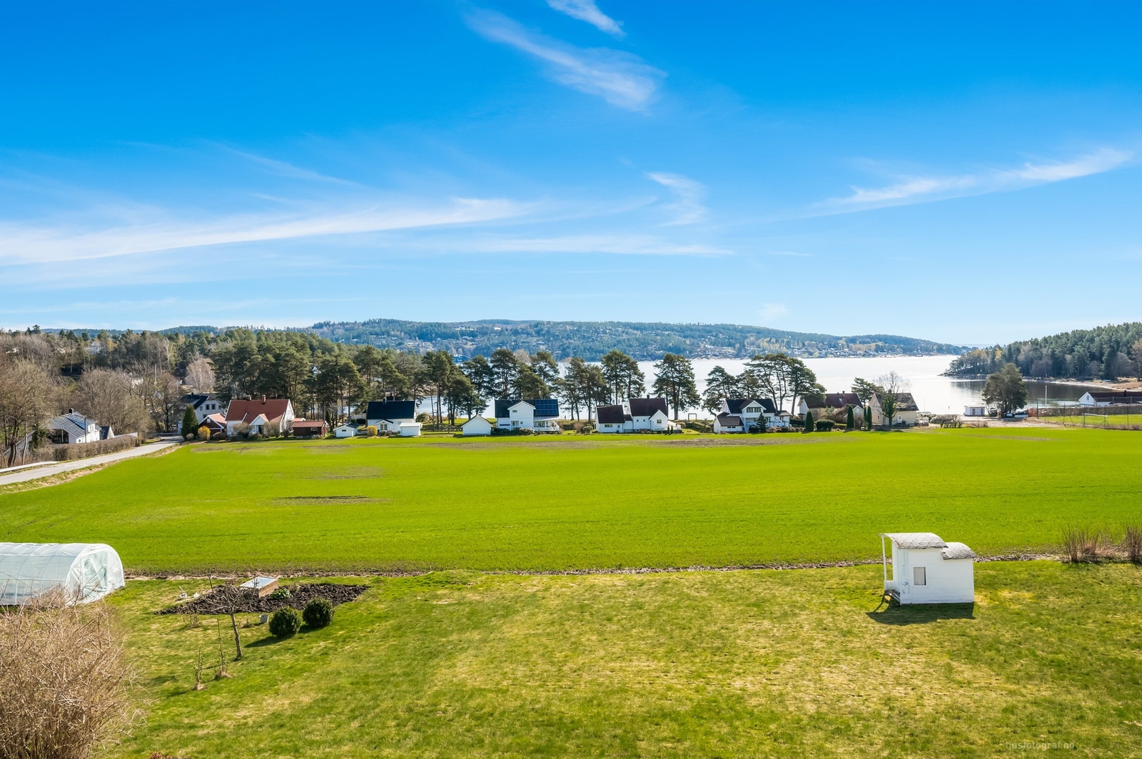 Suveren utsikt fra eiendommen over landbruksarealer og en kort spasertur ned til badestrand, friarealer og Bergerbukta. Galleribilde