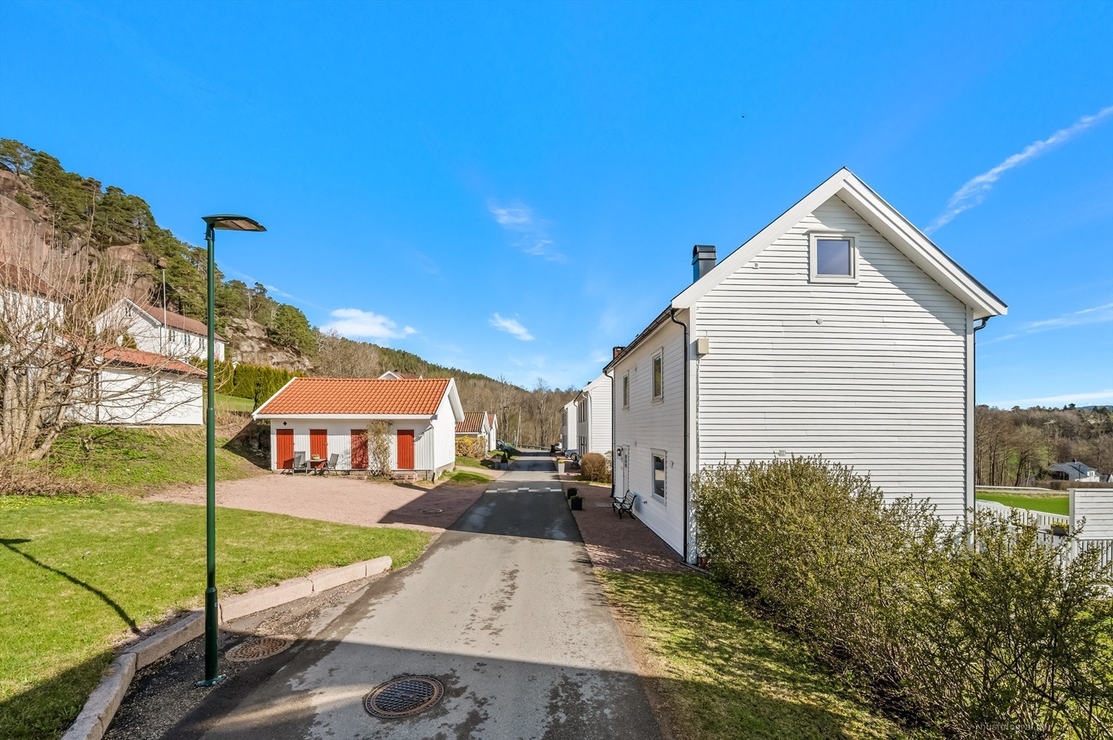 På andre siden av veien er det tilgang til egen tomt med parkeringsplasser (4 stk iflg selger) og halvpart av et frittstående bodanlegg på ca. 21 kvm med boder. Galleribilde