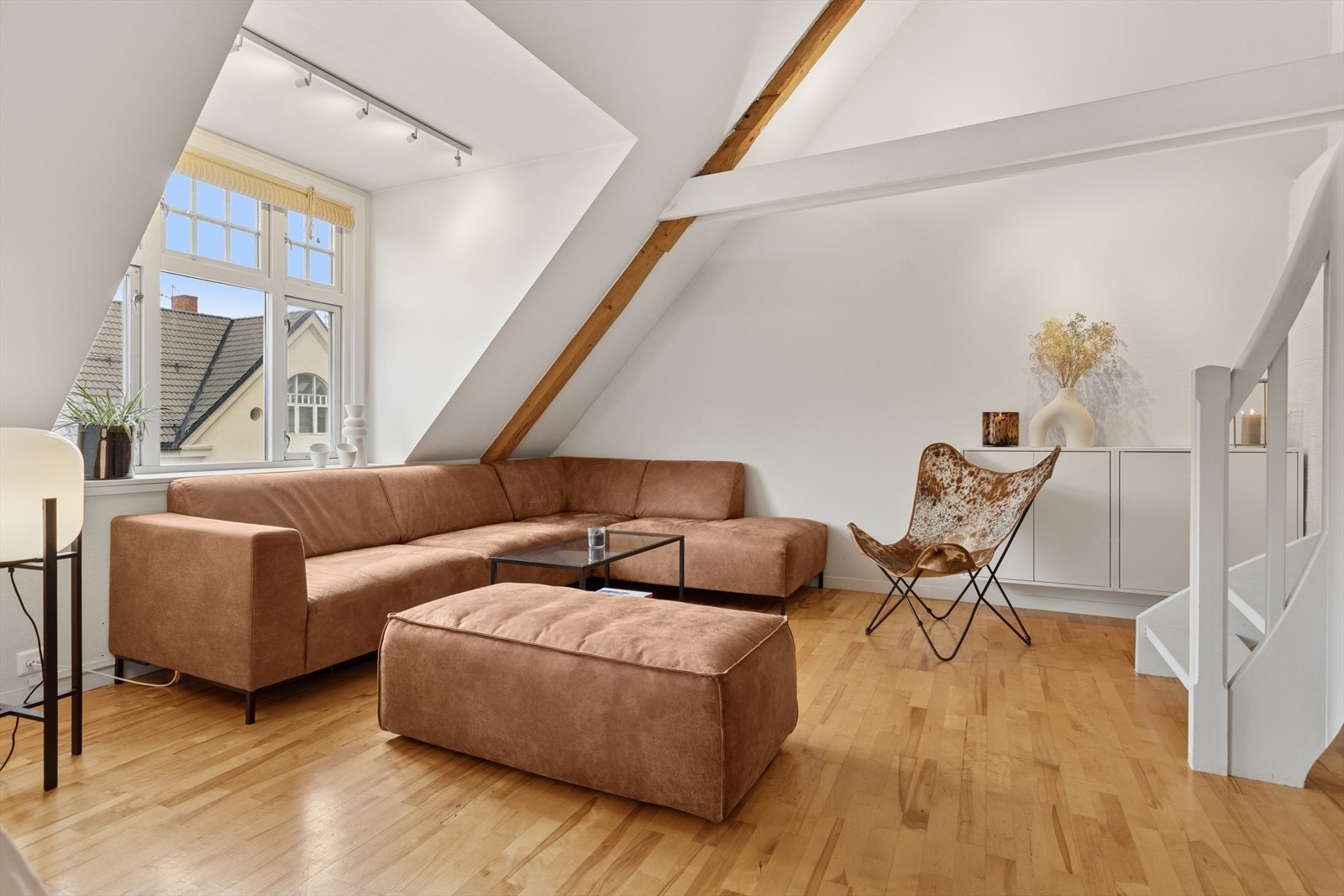 En flott kombinasjon av høy himling, skråtak og delvis åpen løsning mellom etasjene gir et luftig preg. Galleribilde