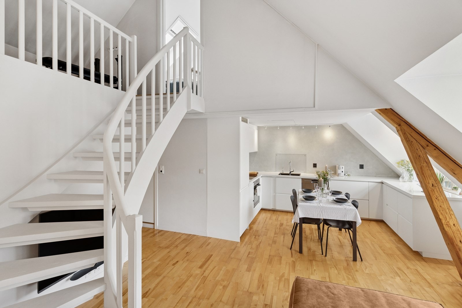 Leilighet med en flott kombinasjon av høy himling, skråtak og delvis åpen løsning mellom etasjene som gir et luftig preg. Galleribilde