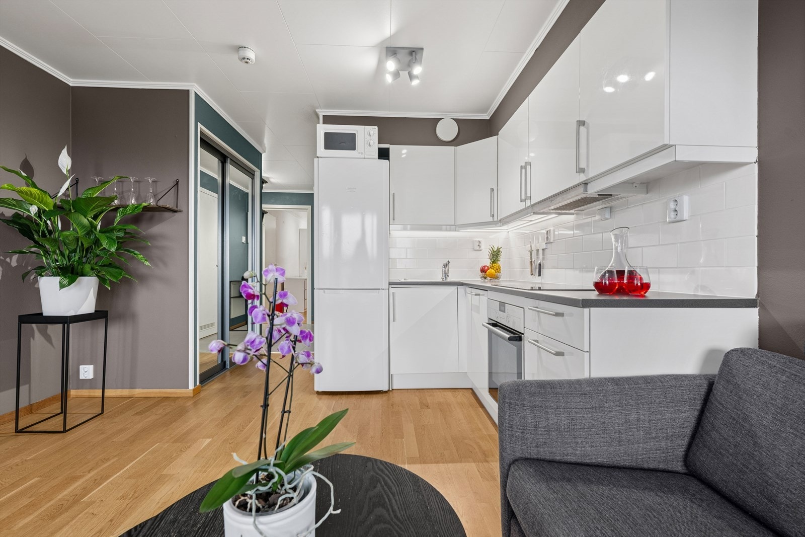 Stilrent og moderne kjøkken med hvite slette fronter og benkeplate av typen laminat. Galleribilde