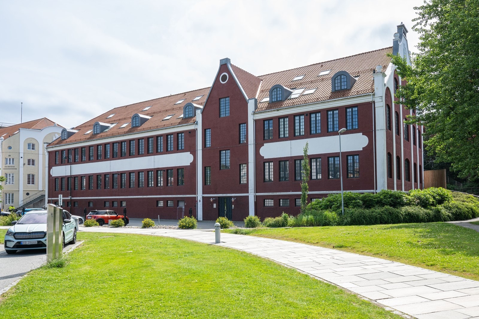 Velkommen til denne lekre og tidløse 2-roms leiligheten i ettertraktede Bjellandgården! Den røde og hvitmalte murbygningen ble reist allerede i 1911 og var Norges hermetikkonge Christian Bjellands eget papir- og blikktrykkeri. Galleribilde