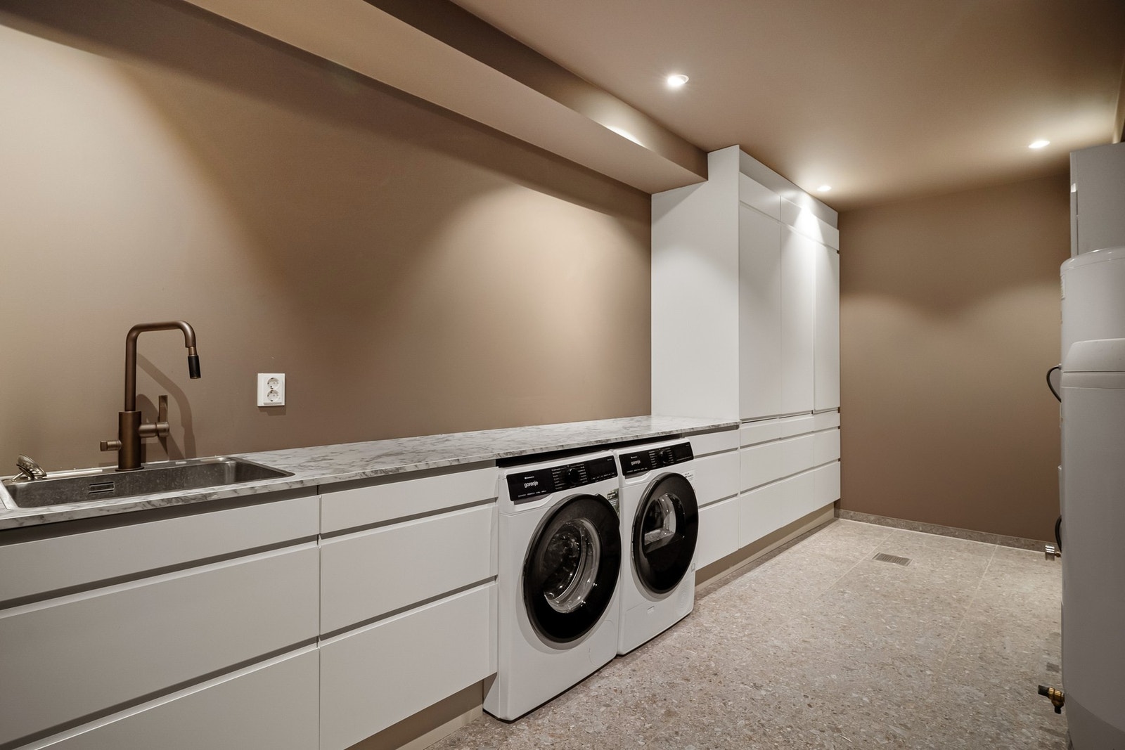 Romslig og funksjonelt vaskerom/teknisk rom med god skap- og benkeplass. Laminat benkeplate. Galleribilde