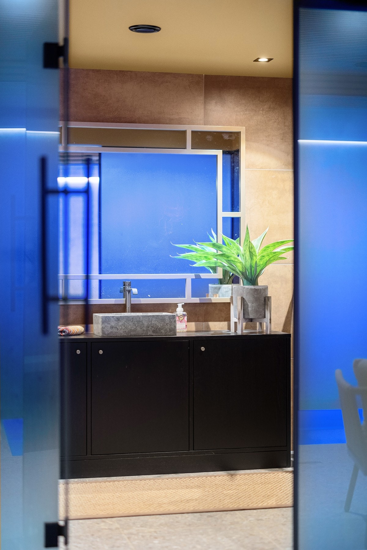 Delikat bad og badstue med gjennomført fargepalett, eksklusive materialvalg og belysning som skaper en lun og avslappende atmosfære. Galleribilde