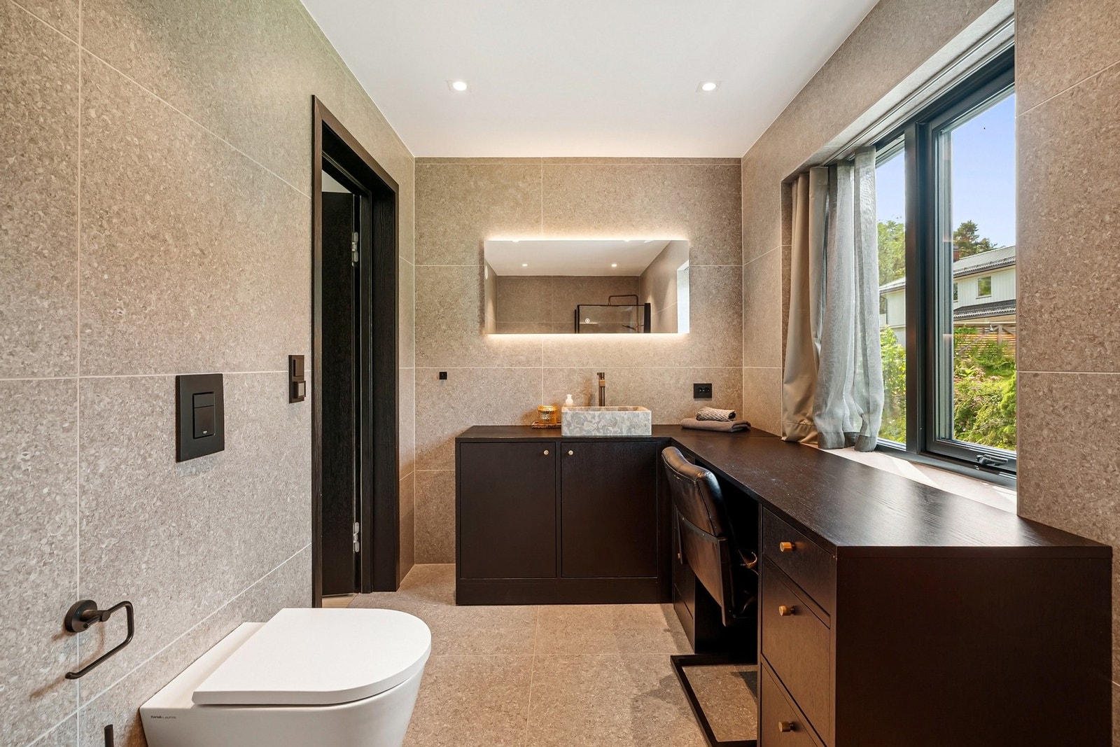 Gjennomført med mørke innredningsdetaljer og integrert speillys. Galleribilde