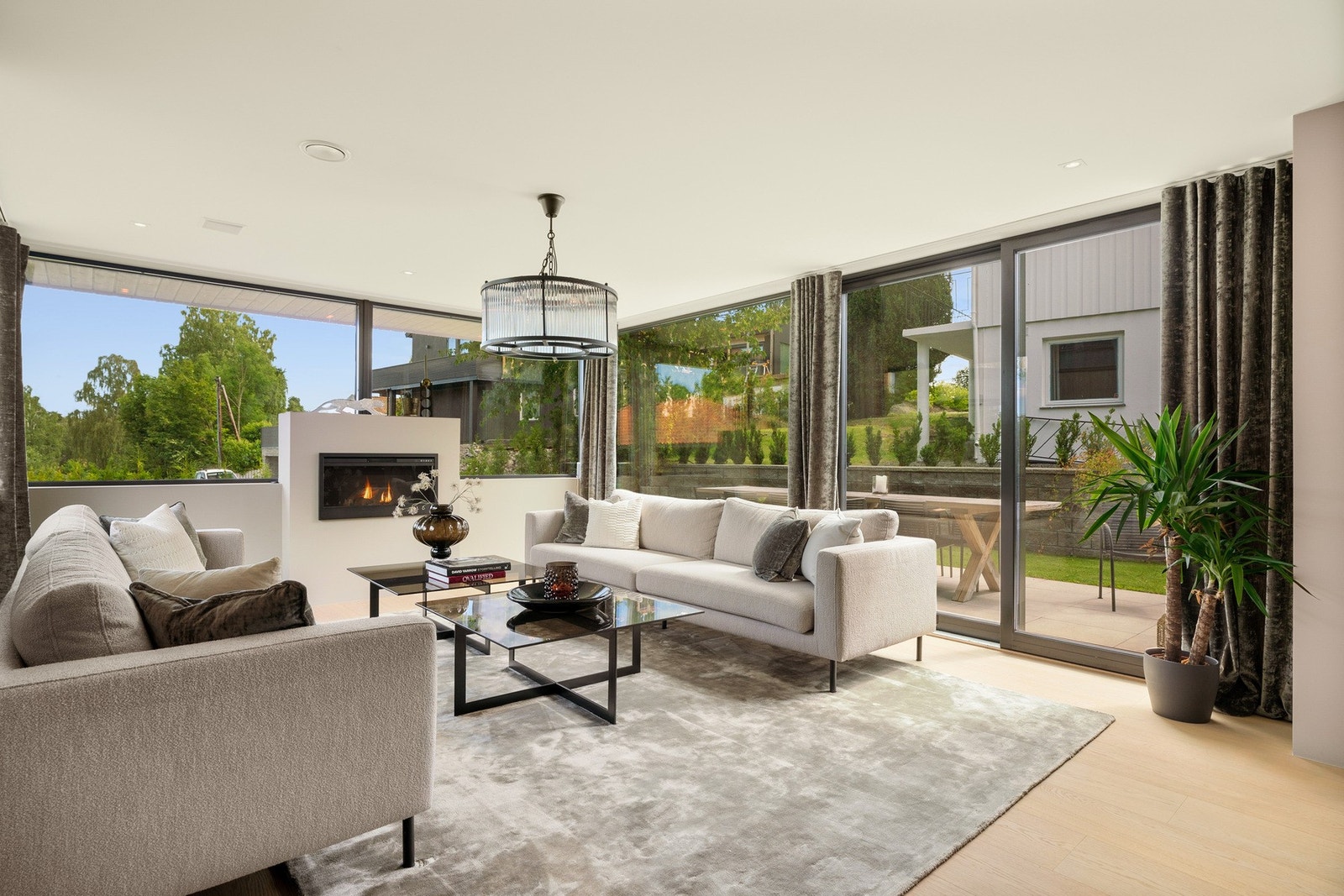 Lys og innbydende stue med store vindusflater, peis og direkte utgang til hage. Galleribilde