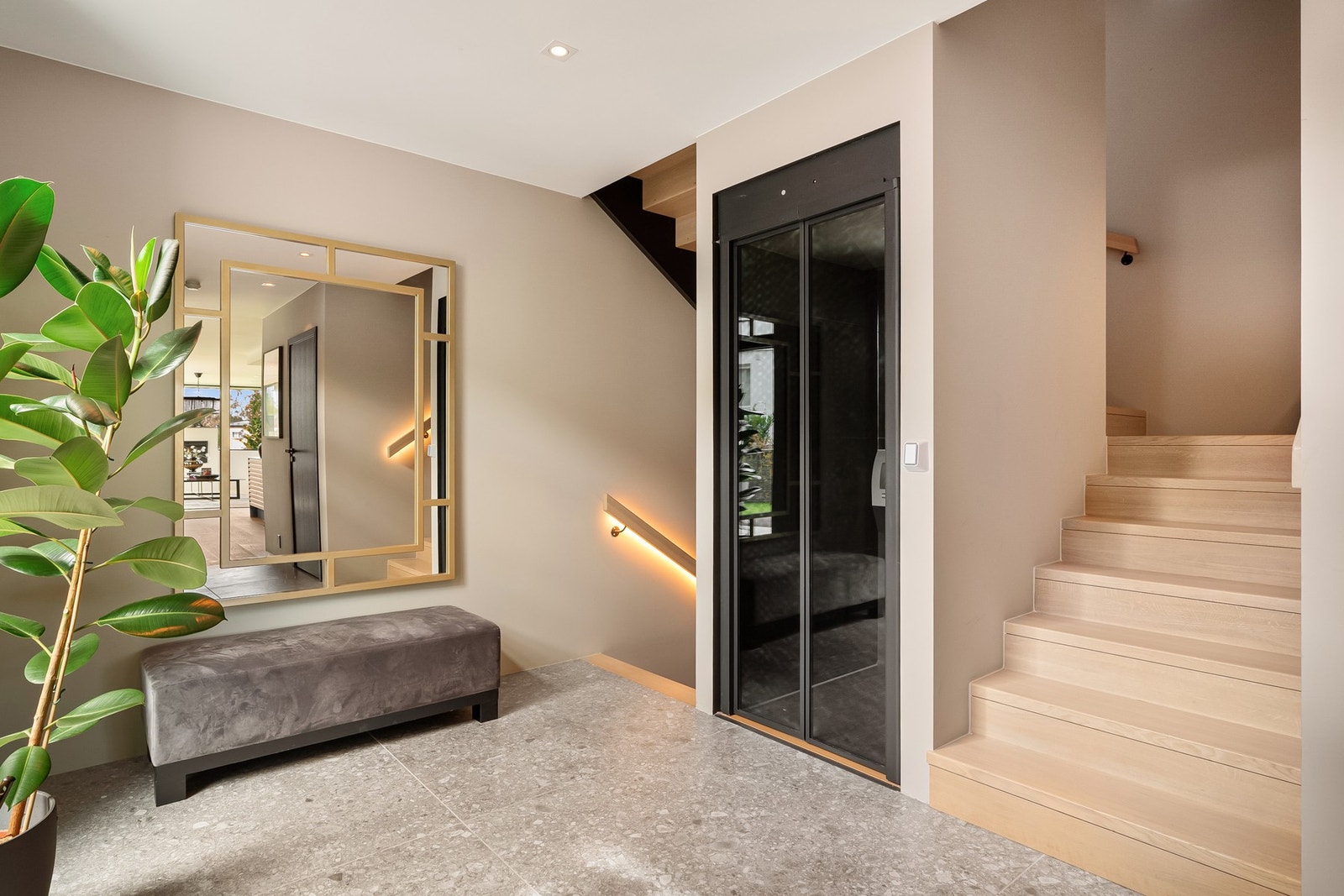 Lyst og stilrent trapperom i 1.etasje med heis mellom etasjene. Galleribilde