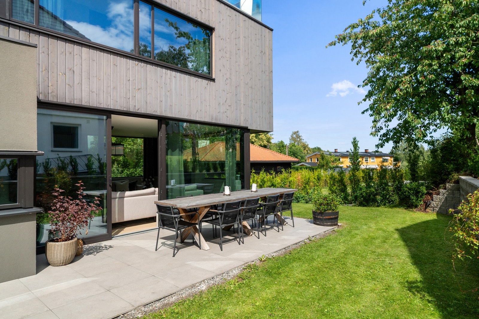 Solrik og skjermet uteplass med god plass til langbord - perfekt for hyggelige måltider og sosiale sammenkomster i grønne omgivelser. Galleribilde