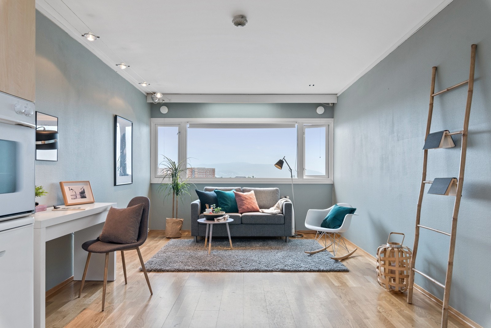 Gangen fordeler seg videre inn til leilighetens baderom og oppholdsrom. Oppholdsrommet måler 21,8 kvm og har en praktisk planløsning. Galleribilde