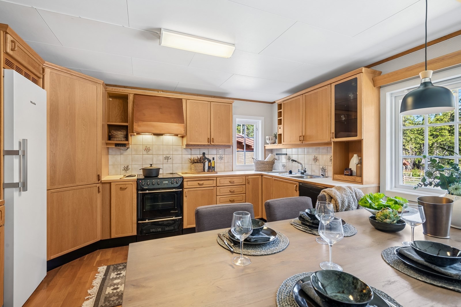 Kjøkkeninnredningen har rikelig med lagringsløsninger gjennom et generøst antall skap og skuffer, og det er nisjer for frittstående hvitevarer som komfyr, oppvaskmaskin og kjøleskap. Galleribilde