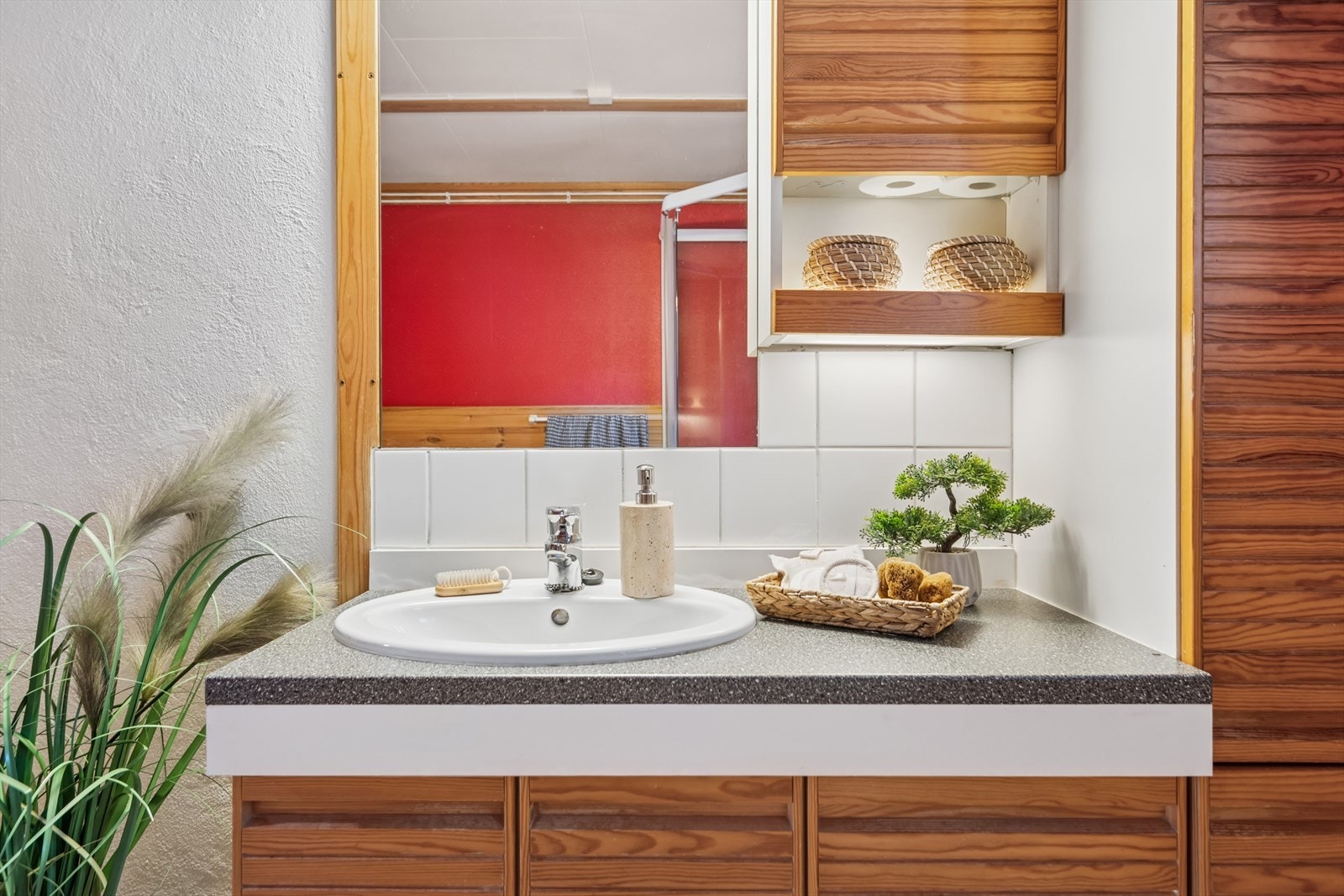 Baderomsinnredning med laminat benkeplate og nedfelt servant, underskap, høyskap og overskap, speil og belysning. Galleribilde