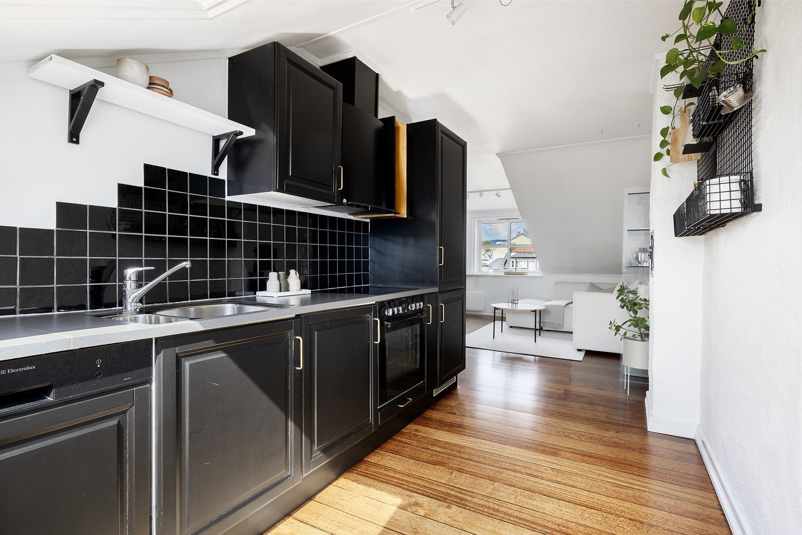 Kjøkkeninnredningen består av profilerte fronter og laminert benkeplate med nedfelt kum. Det er lagt fliser over kjøkkenbenken. Galleribilde