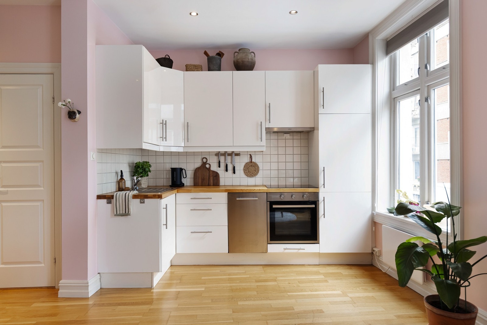 Kjøkkeninnredningen er tidløs og har hvite slette fronter, samt heltre benkeplate med nedfelt kum i rustfritt stål. Galleribilde