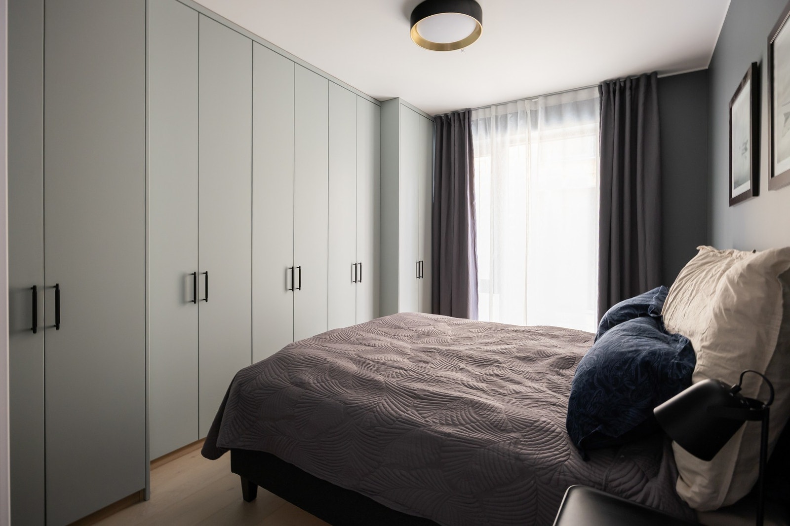 Spesialtilpasset garderobeløsning langs hele soveromsveggen med dybde tilpasset rommets utforming. Galleribilde