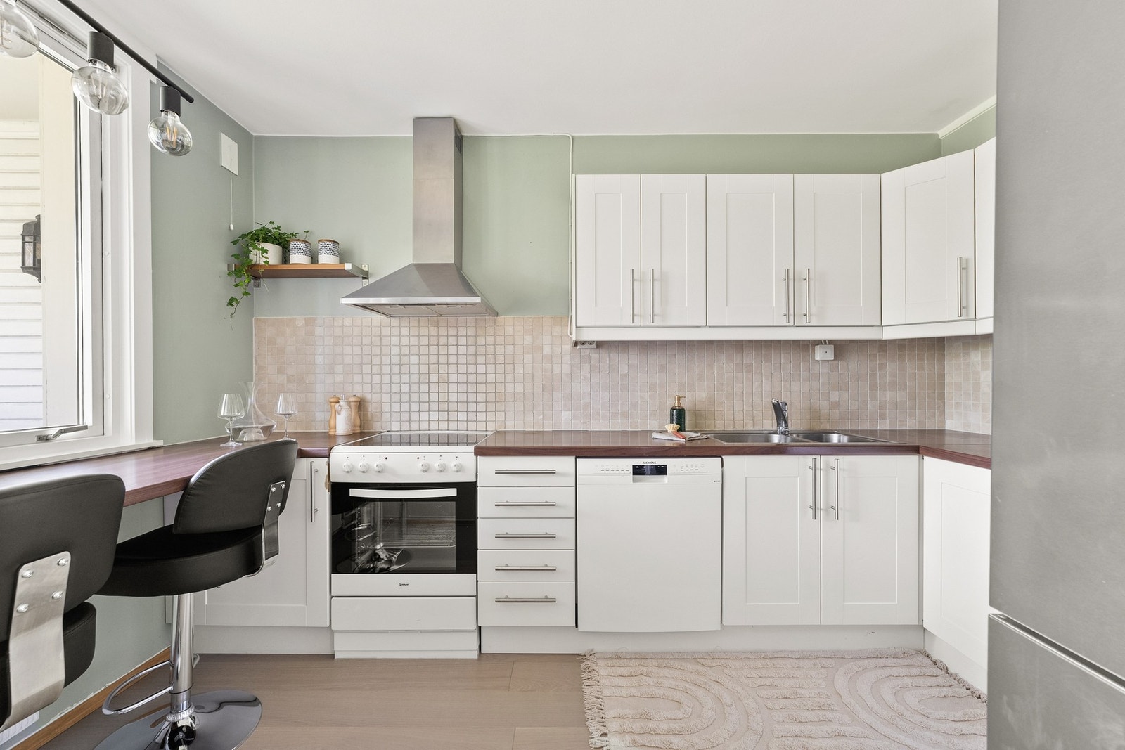 Klassisk og funksjonelt kjøkken med hvite fronter og god skapplass. Galleribilde