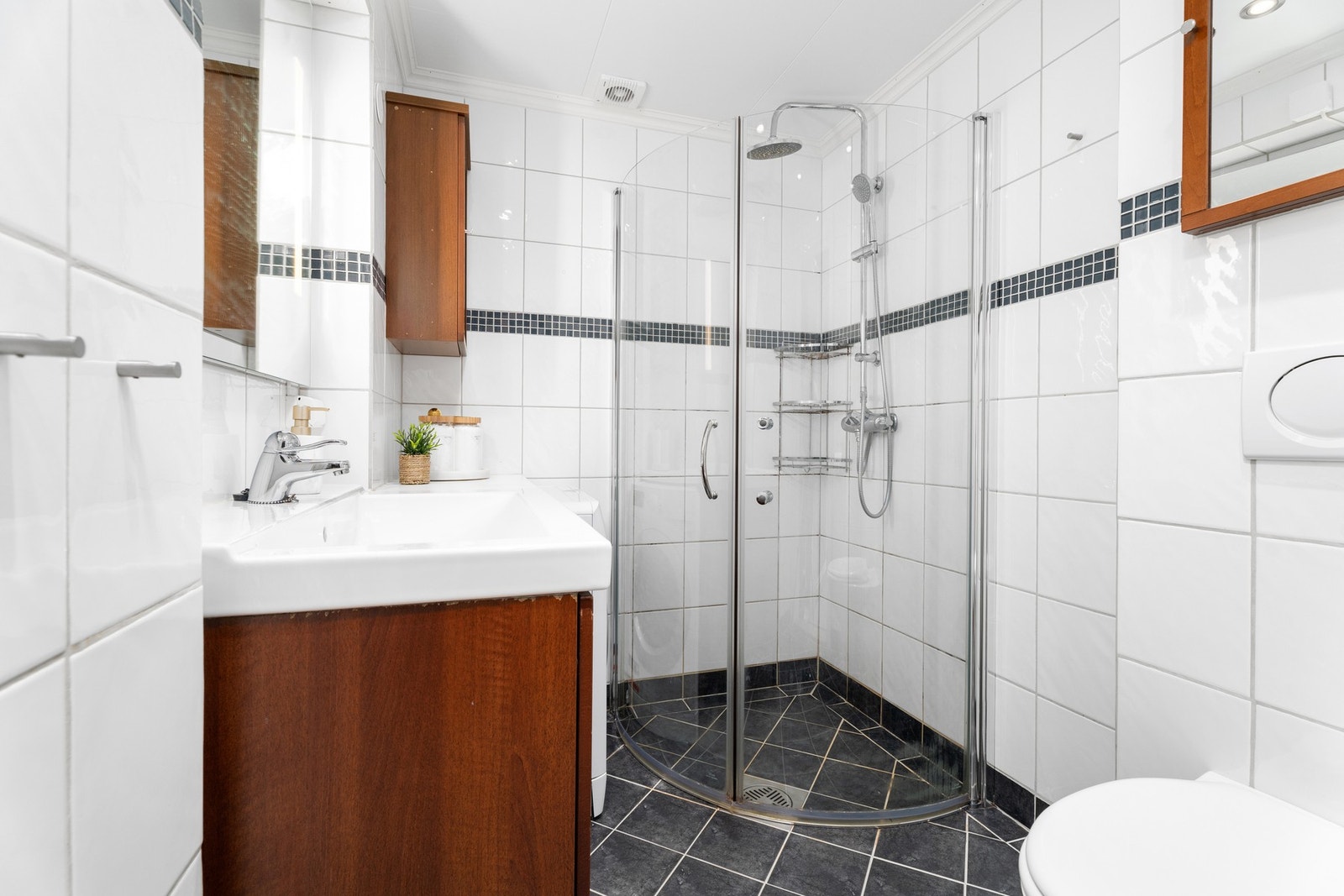 Baderommet er helfliset. Innfellbar dusj gjør det enklere å utnytte plassen maksimalt. Galleribilde