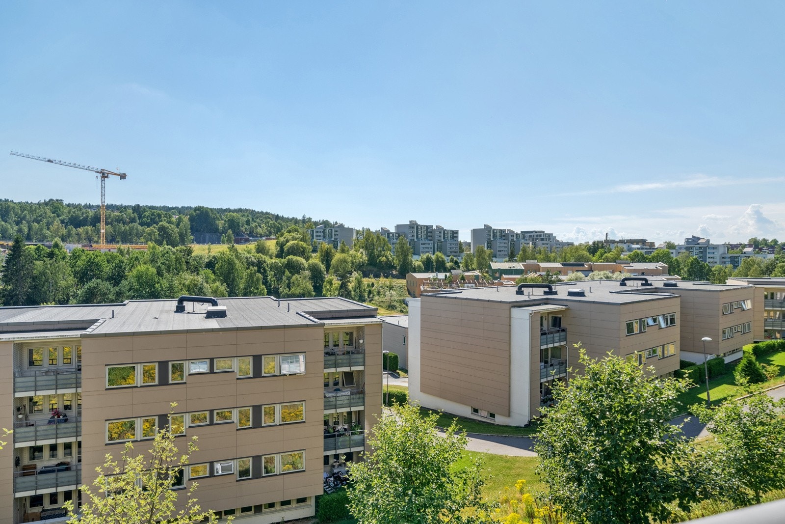 Utsikten fra hovedbalkongen over borettslagets flotte bebyggelse og grøntområder. Galleribilde