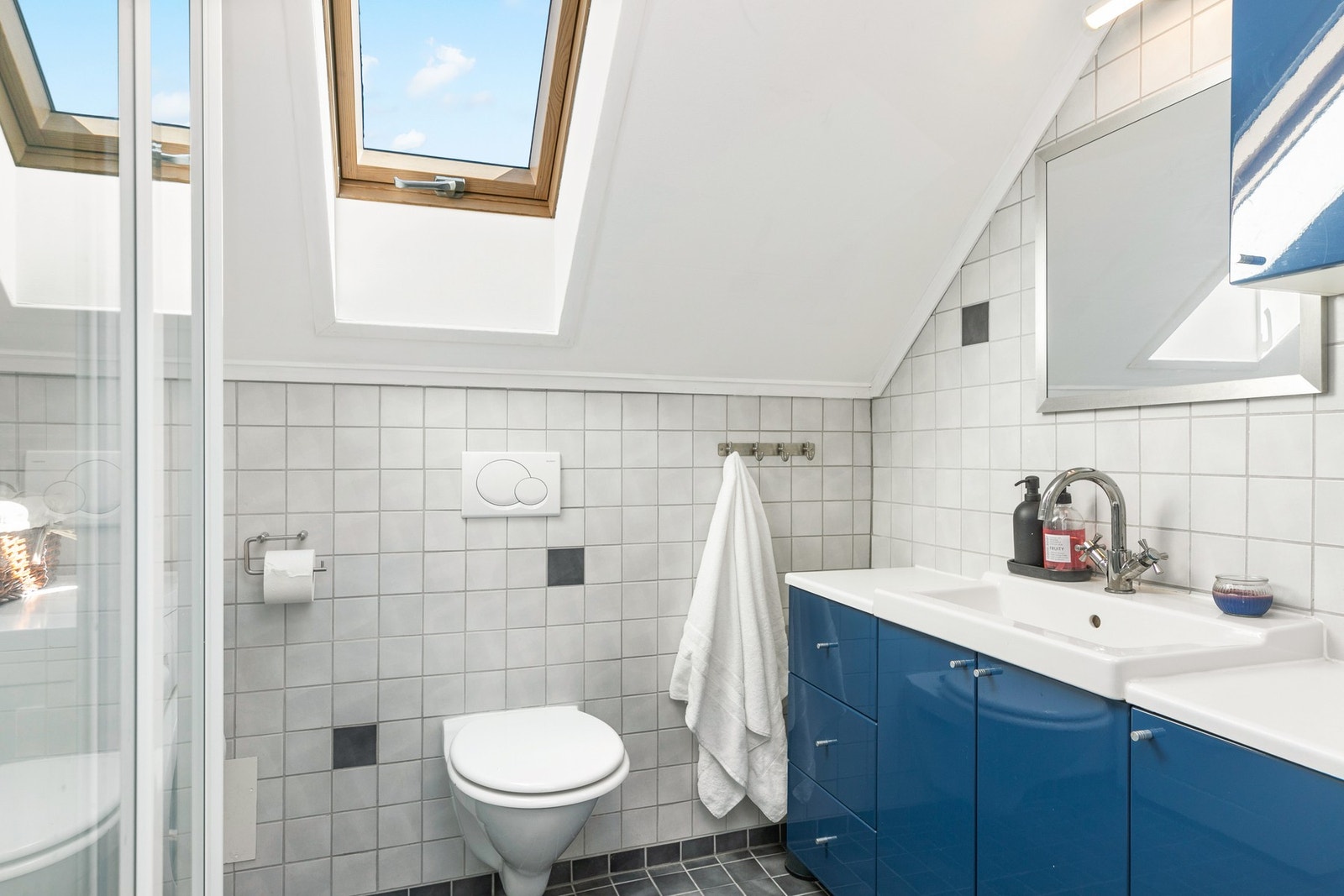 Badet i leiligheten er innredet med vegghengt wc, servantskap, speil, dusjkabinett og vaskemaskin medfølger. Galleribilde