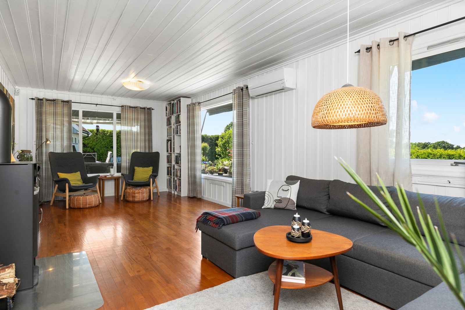 Stuen er lys og pen, med parkett på gulvet og malt panel i tak og på vegger. Galleribilde