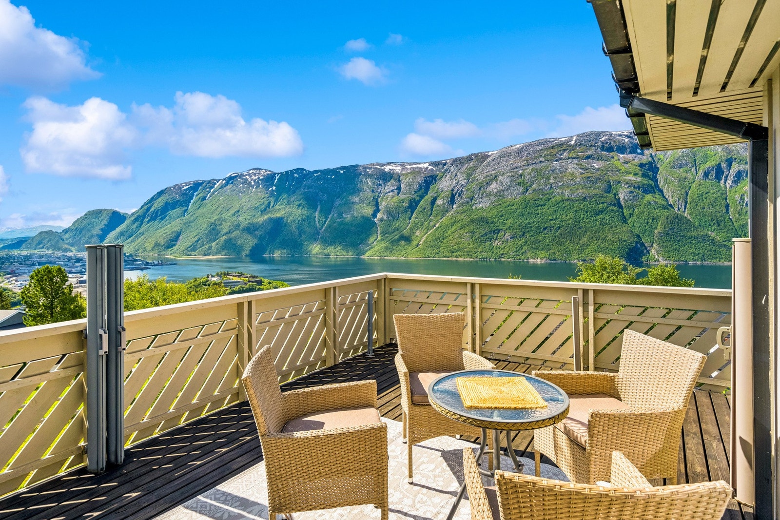 Stor terrasse med utgang fra stuen som byr på utsikt mot fjord og fjell. Galleribilde