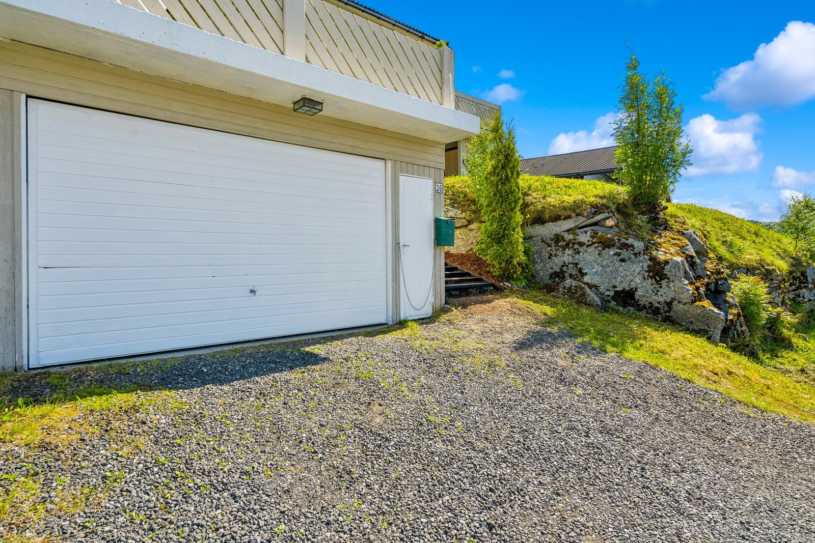 Garasjen har vippeport av tre med motorstyring og adkomst via dørinngang. Det er innlagt strøm med lys og stikk. Galleribilde
