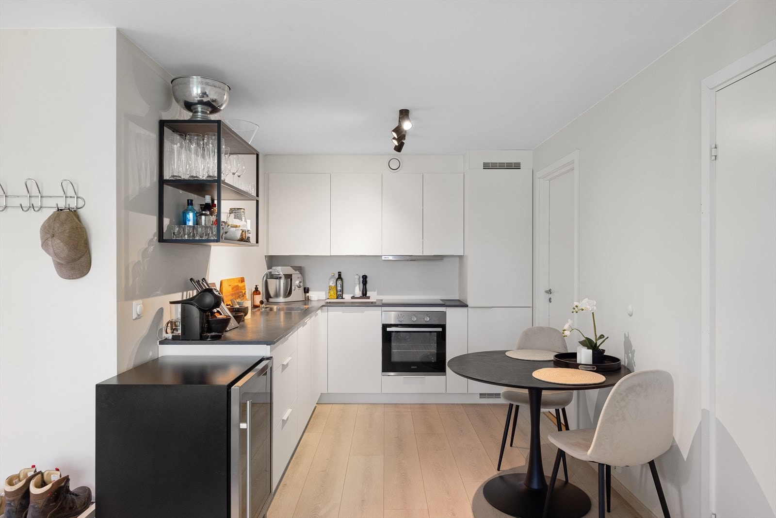 Kjøkkenet har en moderne utforming med slette fronter og en laminat benkeplate med integrert oppvaskkum og ettgreps blandebatteri. Kjøkkenet er utstyrt med integrerte hvitevarer som stekeovn, kombinert kjøl/frys, platetopp og oppvaskmaskin. Galleribilde