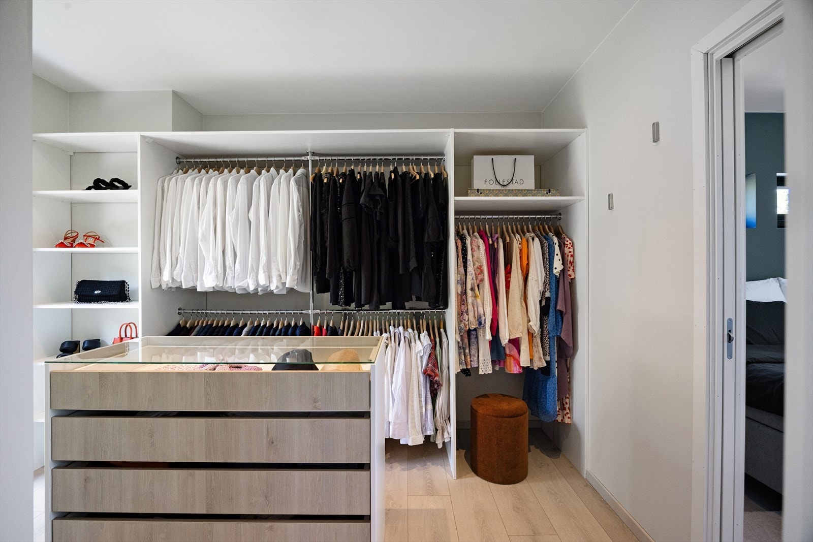 Walk-in-garderoben er utformet med en åpen garderobeløsning som gir god oversikt og rikelig med plass til klær, sko og tilbehør. Galleribilde