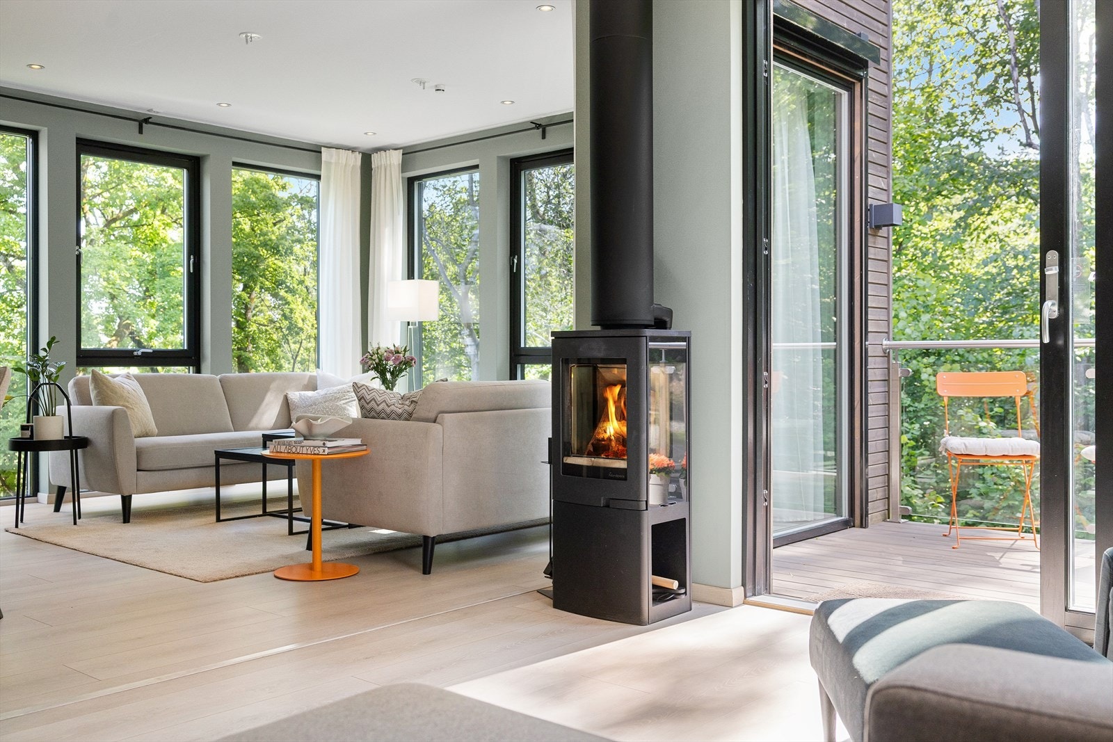 En hyggelig peisovn gir ekstra varme og lun stemning på kjølige dager, og i tillegg bidrar en luft-til-luft varmepumpe i stuen til et behagelig inneklima året rundt. Galleribilde