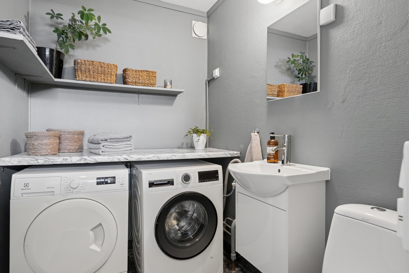 Fra entréen er det adkomst til et praktisk vaskerom, innredet med toalett og servant. Vaskerommet ble overflateopppusset i 2022 og rommer både vaskemaskin og tørketrommel. Galleribilde