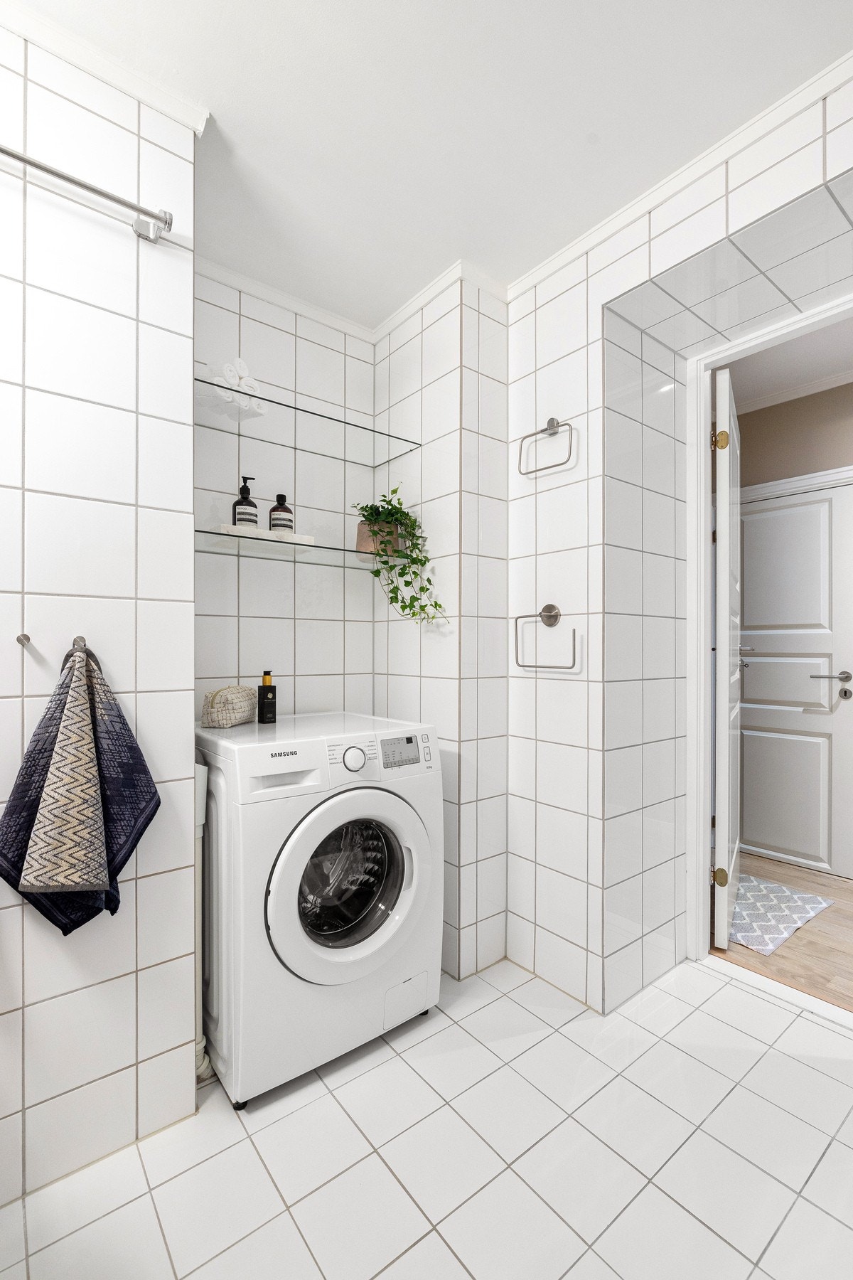 Badet har i tillegg opplegg for vaskemaskin, samt høyskap og glasshyller som gir praktiske oppbevaringsmuligheter. Galleribilde