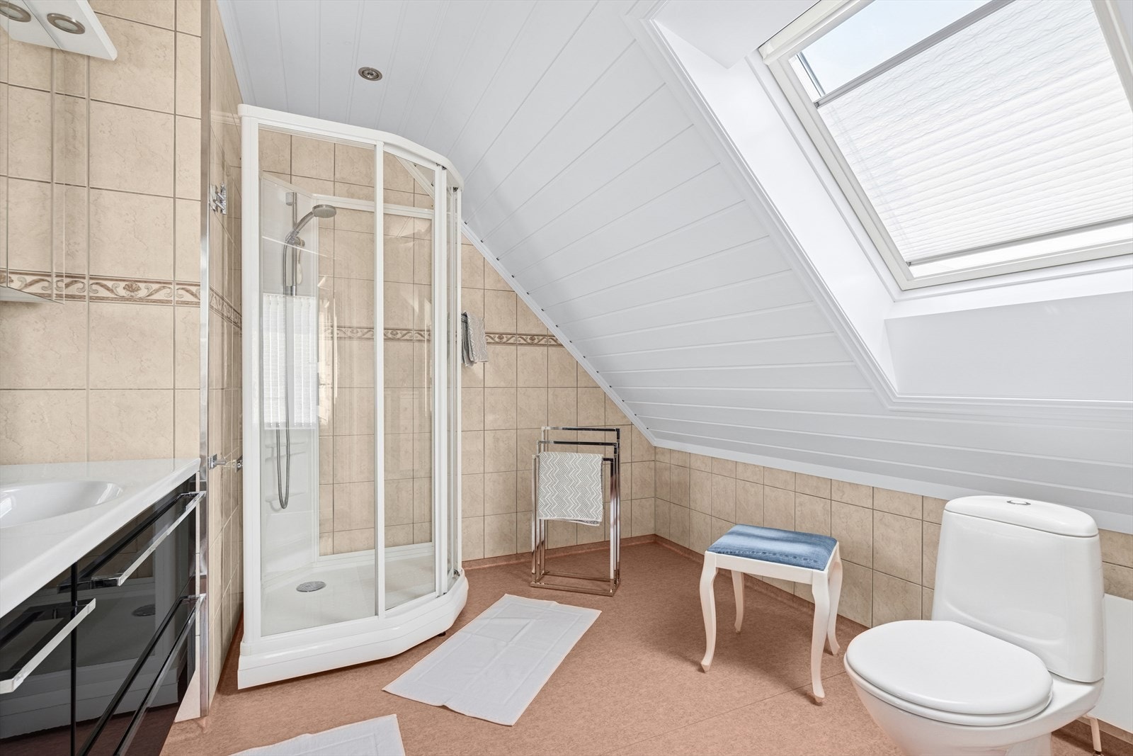 Rommet har innredning med nedfelt servant, toalett og dusjvegger/hjørne. Elektriske varmekabler i gulv. Badet har mekanisk avtrekk med tilluft i dør. Galleribilde