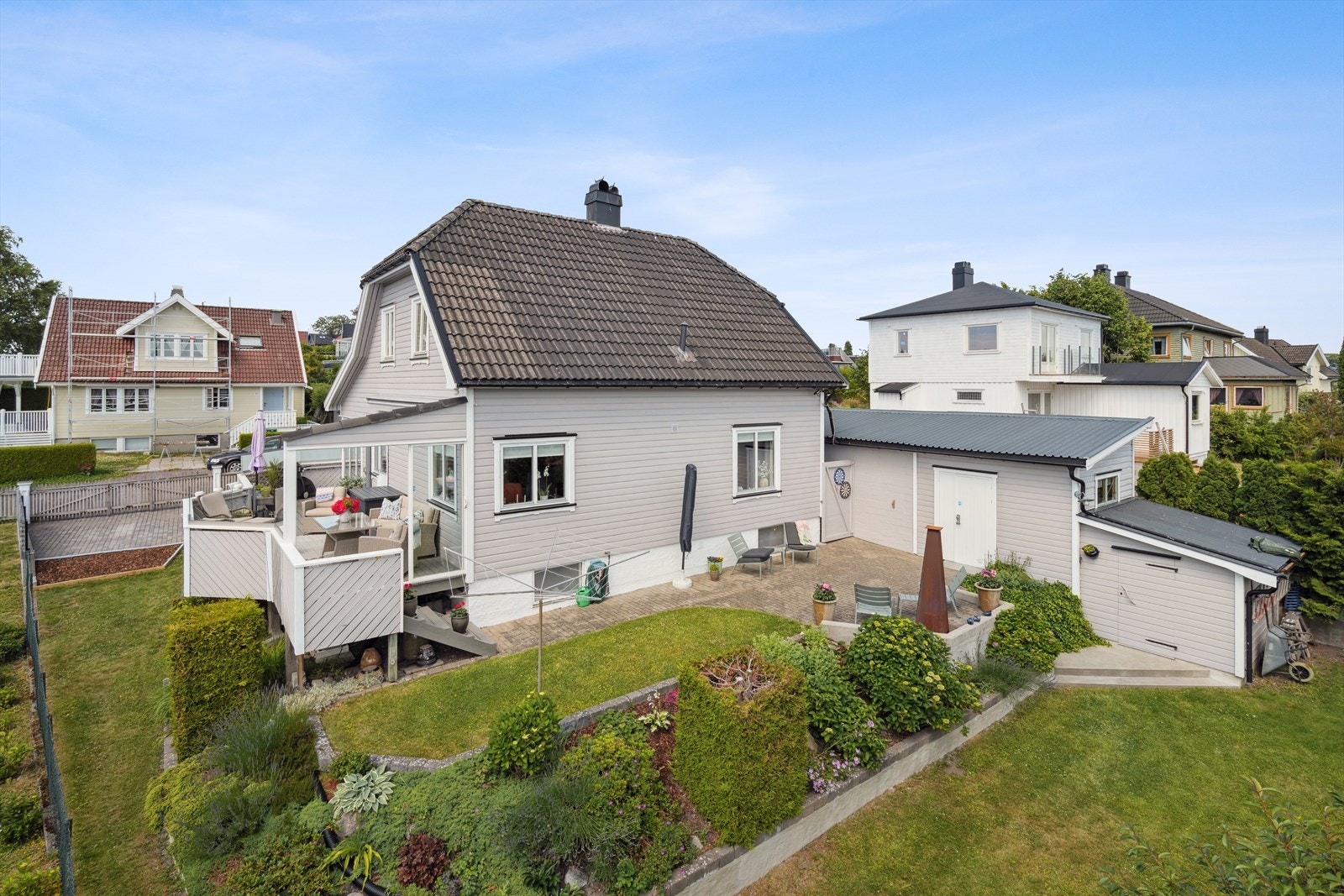 Tomten er pent opparbeidet med plen, terrasser og beplantning. Galleribilde