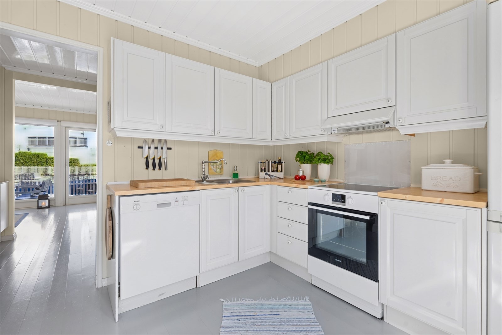 Lyst og funksjonelt kjøkken med kombiskap, fryser, oppvaskmaskin og komfyr. Galleribilde