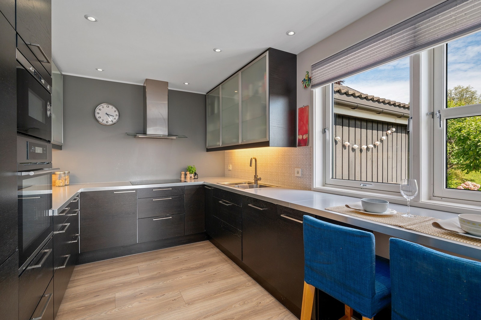 Kjøkkenet fra IKEA er innredet med tidløse mørke fronter og benkeplate av laminat. Praktisk barløsning foran vindu. Galleribilde