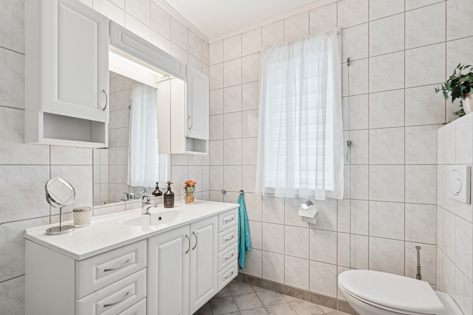 Pent og moderne baderom som ble totalrenovert i 2008. Rommet er innredet med vegghengt toalett, servant med underskap og dusjhjørne med glassvegger. Galleribilde