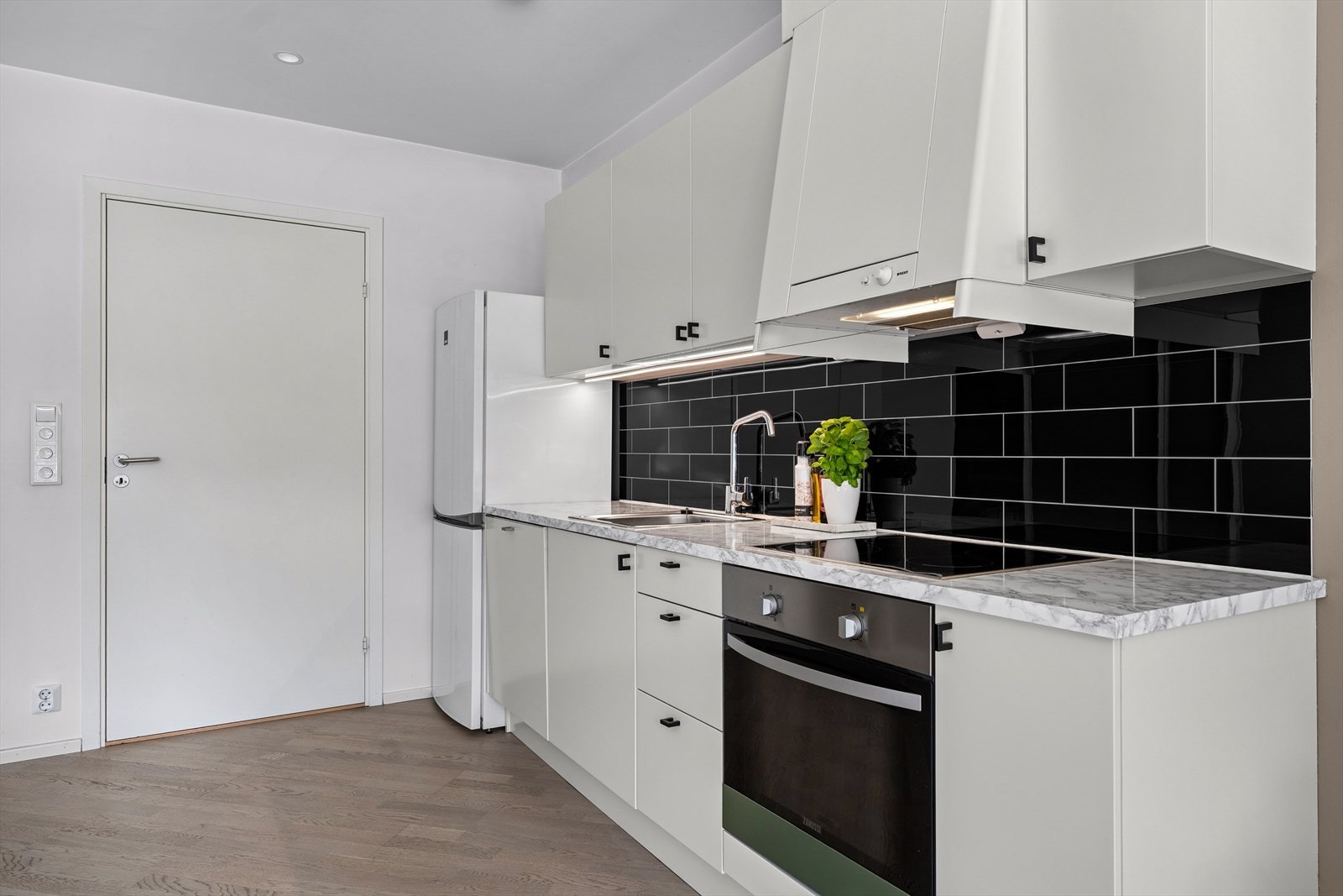 Kjøkkeninnredning med laminerte skrog, glatte fronter og laminert benkeplate med kjøkkenkum. Galleribilde