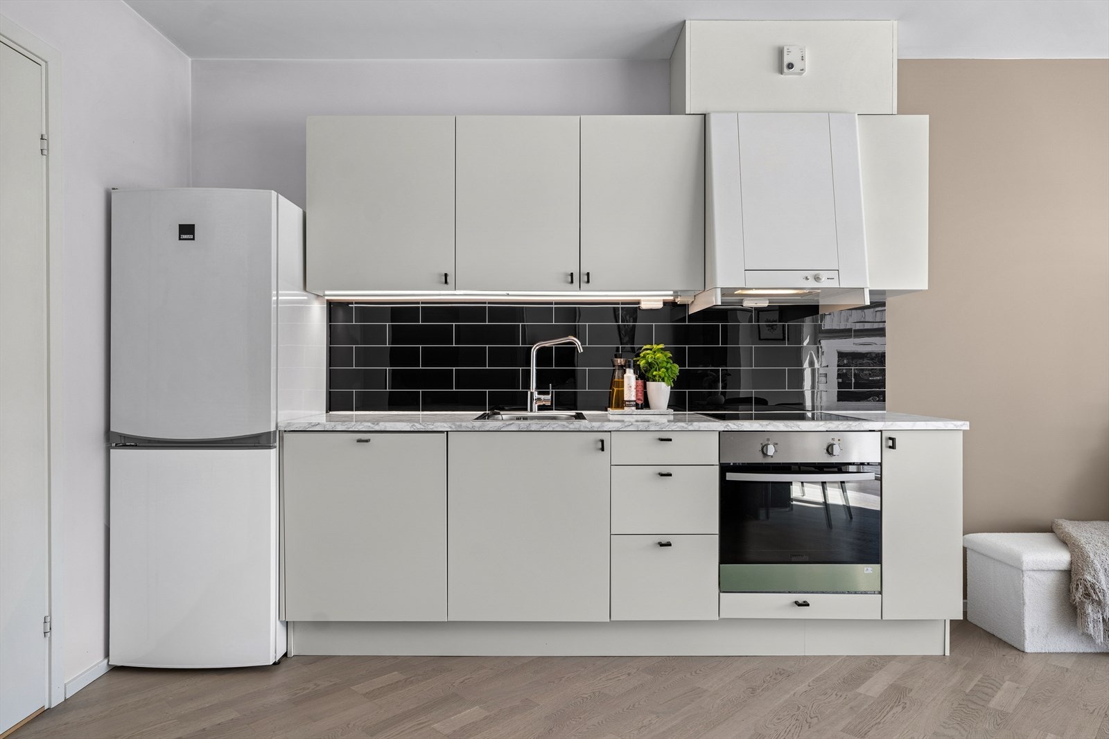 Visuell oppgradering av kjøkken med foliering av benk samt flislagt kjøkkenvegg med imiterte fliser. Galleribilde